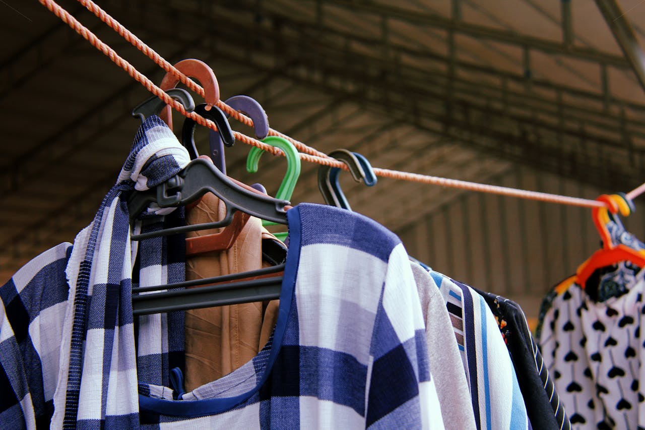 Services-02 Close-up of vibrant clothes hanging on a line, showcasing various patterns and colors on hangers.