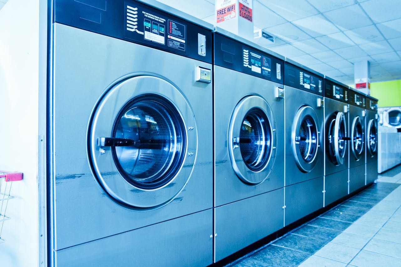 brand-03 Interior of a contemporary launderette featuring advanced stainless steel washing machines.